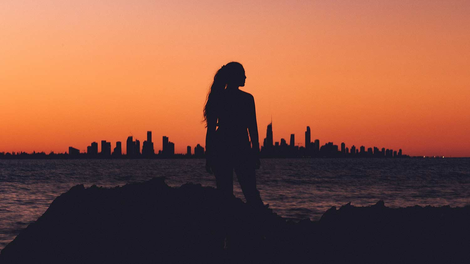 woman standing in front of sunset