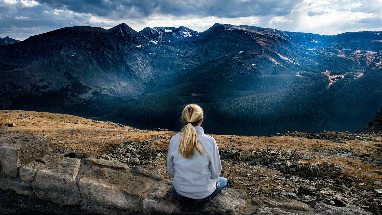 person sitting looking at mountains