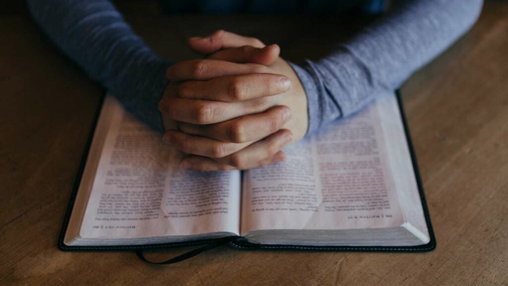 Person Praying with Bible